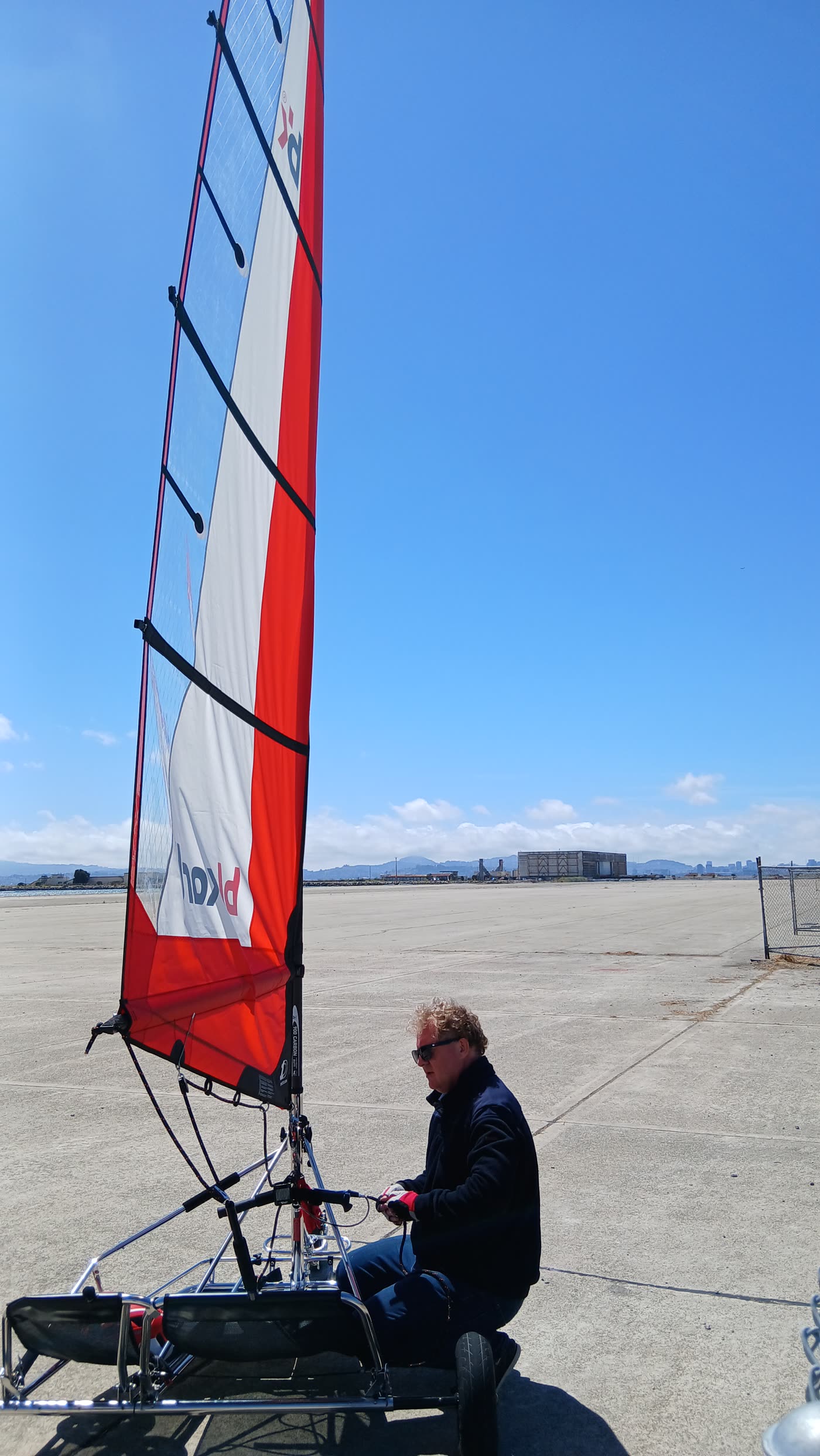 Sail kart with a red-and-white sail on the Oakland flats